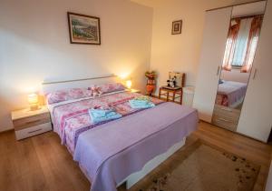 ein Schlafzimmer mit einem großen Bett mit lila Bettwäsche in der Unterkunft Gina in Rijeka
