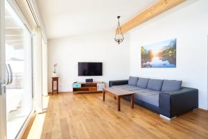sala de estar con sofá azul y TV en Bergblick Acht Mondsee en Innerschwand