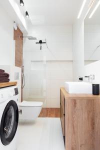 a bathroom with a washing machine and a sink at Apartament Maxim Premium in Darłowo