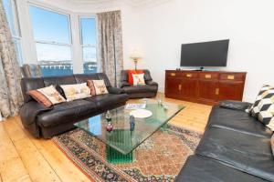 a living room with a leather couch and a glass table at Apartment 'Invertay' Newport on Tay, 15 Minute Drive to St Andrews Golf in Fife