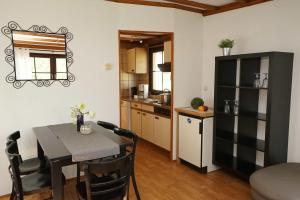 a kitchen and a dining room with a table and chairs at Camping Harfenmühle - Chalet in Mörschied