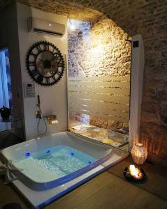 une baignoire jacuzzi dans une chambre avec un mur en pierre dans l'établissement Suite 123 Luxury B&B Con Jacuzzi, à Palo del Colle