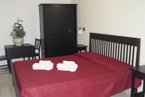 a bedroom with a red bed with towels on it at Oasi Di Casablanca in Lampedusa