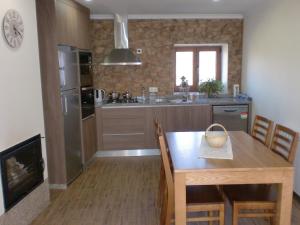 a kitchen with a wooden table and a dining room at Casa do Canto in Macedo de Cavaleiros