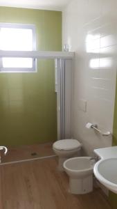 a bathroom with a toilet and two sinks and a window at Casa vacanza Torre Specchia in Torre Specchia Ruggeri