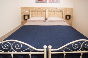 a bedroom with a bed with a blue bedspread at Casa vacanza Torre Specchia in Torre Specchia Ruggeri