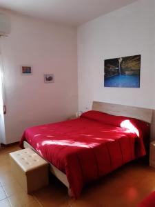 een slaapkamer met een bed met een rood dekbed bij Small Flat in Scafa