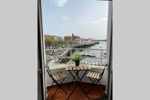 balcón con mesa y sillas y vistas al puerto en Vivienda con impresionantes vistas/apartamento Artza en Bermeo
