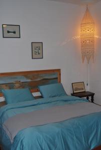 a bedroom with a bed with blue sheets and a lamp at Spiti Anatoli in Karfas