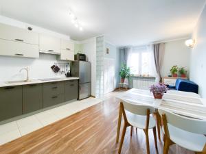 a kitchen and living room with a table and chairs at Apartament Alicji in Ełk
