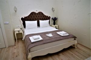 Alacati Eldoris Butik Hotel في ألاتشاتي: غرفة نوم بسرير كبير عليها منشفتين