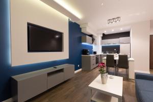 グダニスクにあるAPARTLOGY Aura2 78 - Experience intelligent living while travellingの青い壁にテレビ付きのリビングルーム