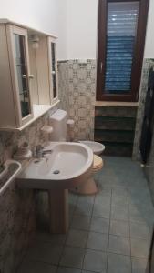 bagno con 2 lavandini, servizi igienici e specchio di Villetta Baia Verde a Gallipoli