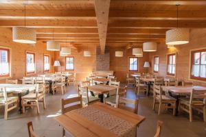 un restaurante con mesas y sillas de madera y ventanas en Wine & Tourism Bračko 