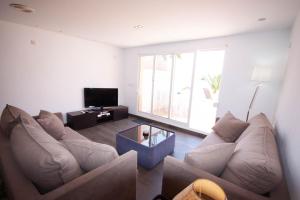 a living room with a couch and a tv at Soling 65 in La Manga del Mar Menor