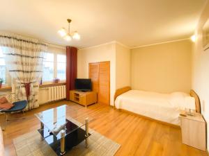 a bedroom with a bed and a desk and a tv at Apartament Alicji in Ełk