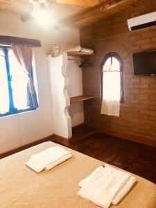 um quarto com duas toalhas brancas numa cama em Refugios del Callejón em San Carlos