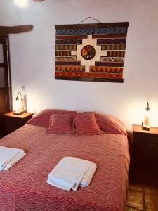 a bedroom with a bed with a clock on the wall at Refugios del Callejón in San Carlos