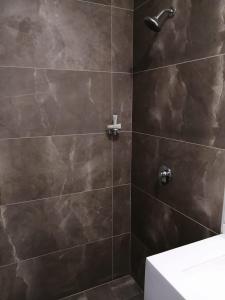 a bathroom with a shower with brown tiles at Vive Place in Aguascalientes