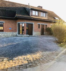 a brick house with a driveway in front of it at Gîte D'han le coin in Han-sur-Lesse