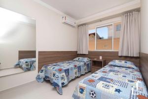 een slaapkamer met 2 bedden en een raam bij Apartamento térreo com 02 dormitórios in Canto Grande