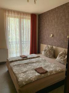 a bedroom with a large bed with a window at Balaton Apartmanház in Siófok