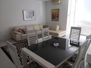 uma sala de estar com uma mesa, cadeiras e um sofá em Petar's Apartment Centar em Skopje