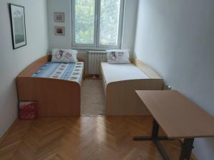 duas camas em um quarto com uma escrivaninha e uma mesa em Petar's Apartment Centar em Skopje