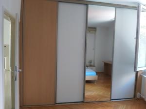 uma porta de vidro deslizante numa sala com um quarto em Petar's Apartment Centar em Skopje mais 2 fotografias