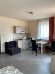 a kitchen and living room with a couch and a table at Balaton Apartmanház in Siófok