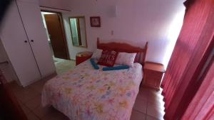 a bedroom with a bed with a floral bedspread at Uvongo cabanas 5A in Margate