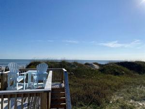 two chairs and a table on a deck overlooking the ocean at NC 12 56821-11 Condo in Hatteras +5 photos