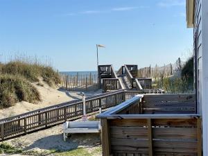 a walkway to the beach with benches and a fence at NC 12 56821-11 Condo in Hatteras