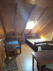 an attic room with two beds and a table at Domek letniskowy 8 -osobowy in Sianozety