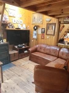 a living room with a couch and a flat screen tv at Domek letniskowy 8 -osobowy in Sianozety