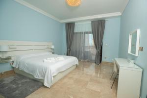 a bedroom with a bed and a desk and a window at Gorgeous 2BR in Fairmont in Dubai