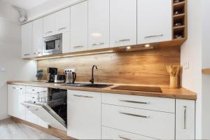 a kitchen with white cabinets and a wooden counter top at PIANISSIMO in Krakow