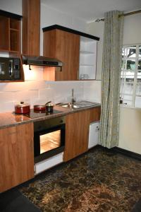 a kitchen with an oven and a sink in it at Annavilla7 Lilongwe Aparthotel in Lilongwe