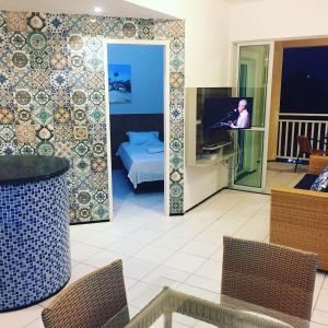 a living room with a television and a bedroom at Blue Beach Apartments in Aquiraz