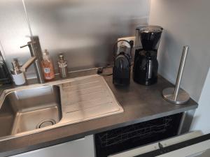 eine Küchentheke mit einer Spüle und einer Kaffeemaschine in der Unterkunft SeaLodge4you in Bredene