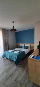 a bedroom with two beds and a blue wall at Apartamenty Jasieńczyk in Mielenko