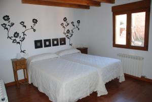 ein Schlafzimmer mit einem weißen Bett und einem Fenster in der Unterkunft Casa Rural Margarita'S in Sotillo de la Ribera