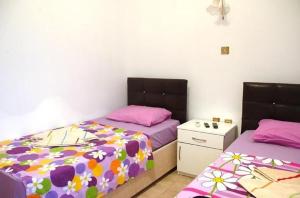 2 camas en una habitación con sábanas rosas y moradas en Bilsu Volley Hotel, en Cesme