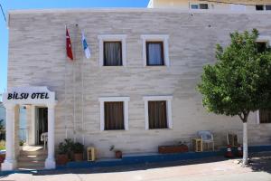 un edificio con dos banderas delante en Bilsu Volley Hotel, en Cesme