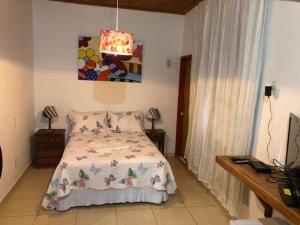 a bedroom with a bed and a painting on the wall at Pousada Joaninha in Tiradentes
