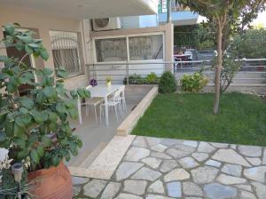 eine Terrasse mit Tisch und Stühlen in einem Hof in der Unterkunft ΔΕΣΠΟΙΝΑ in Néa Péramos