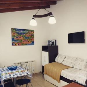 1 dormitorio con cama, mesa y TV en Cabañas El Parquecito en Olavarría