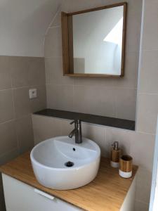 a bathroom with a white sink and a mirror at Appartement rénové en duplex à proximité du centre in Le Palais