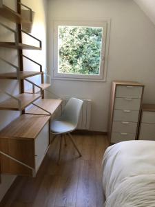 a bedroom with a desk and a bed and a window at Appartement rénové en duplex à proximité du centre in Le Palais