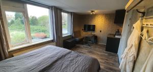 een hotelkamer met een bed, een bureau en een raam bij B&B Mackenzieplaats in Wilp